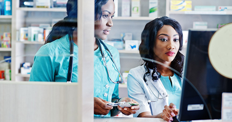 Two african american pharmacist working in drugstore at hospital