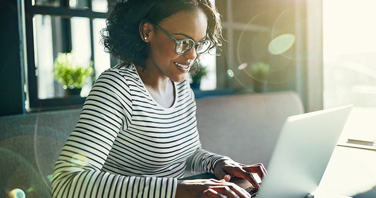 Young African woman smiling and working online with a laptop